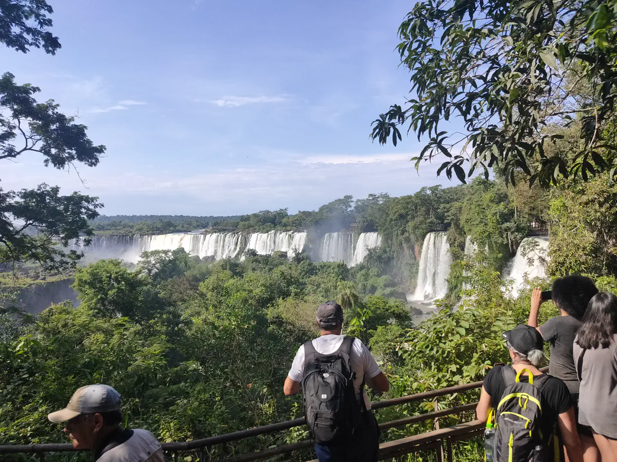 アルゼンチン側展望台でイグアスの滝を背景に写真を撮る観光客たち