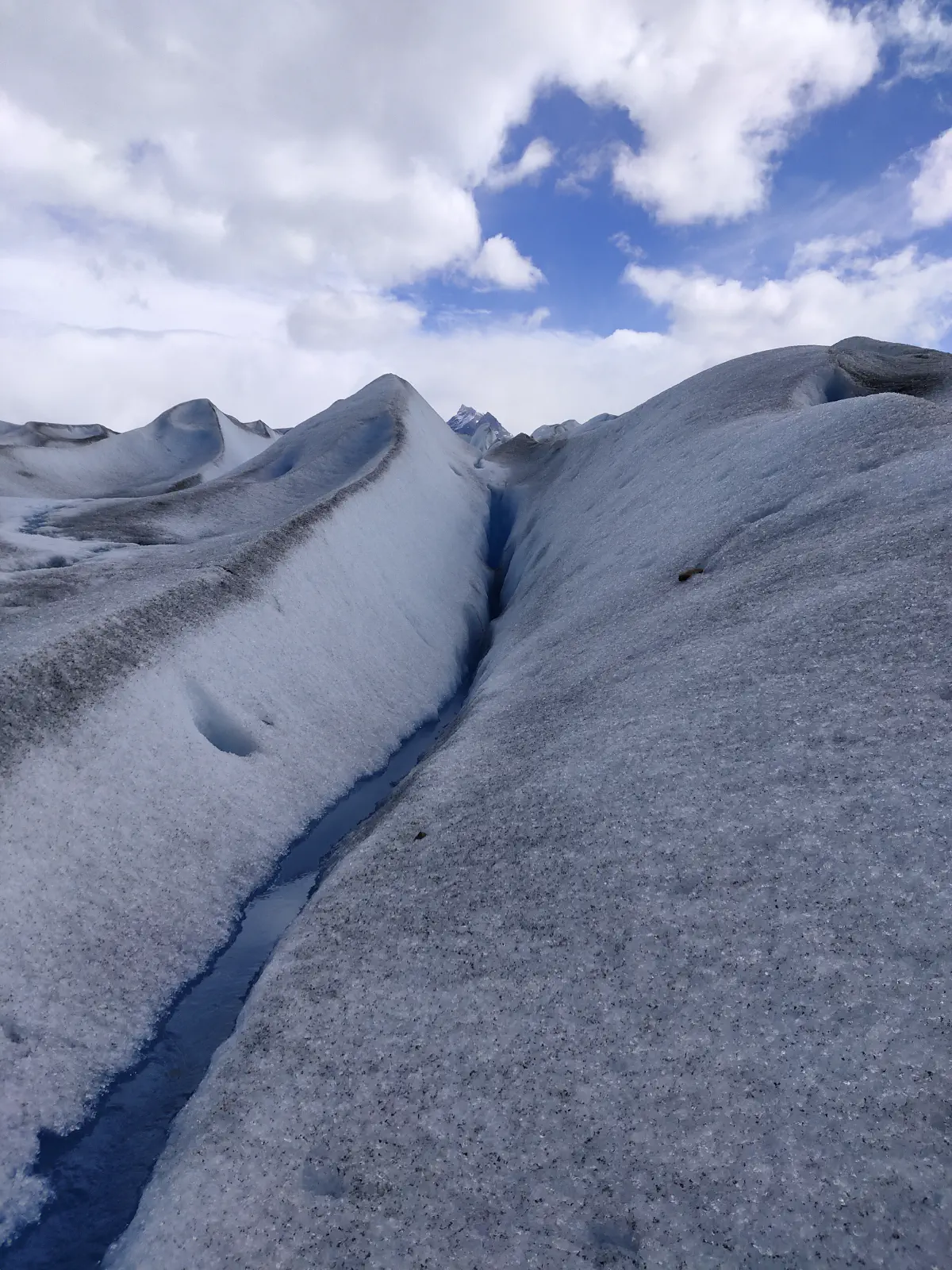 氷河の起伏した表面を蛇行する細い融解水の流れ