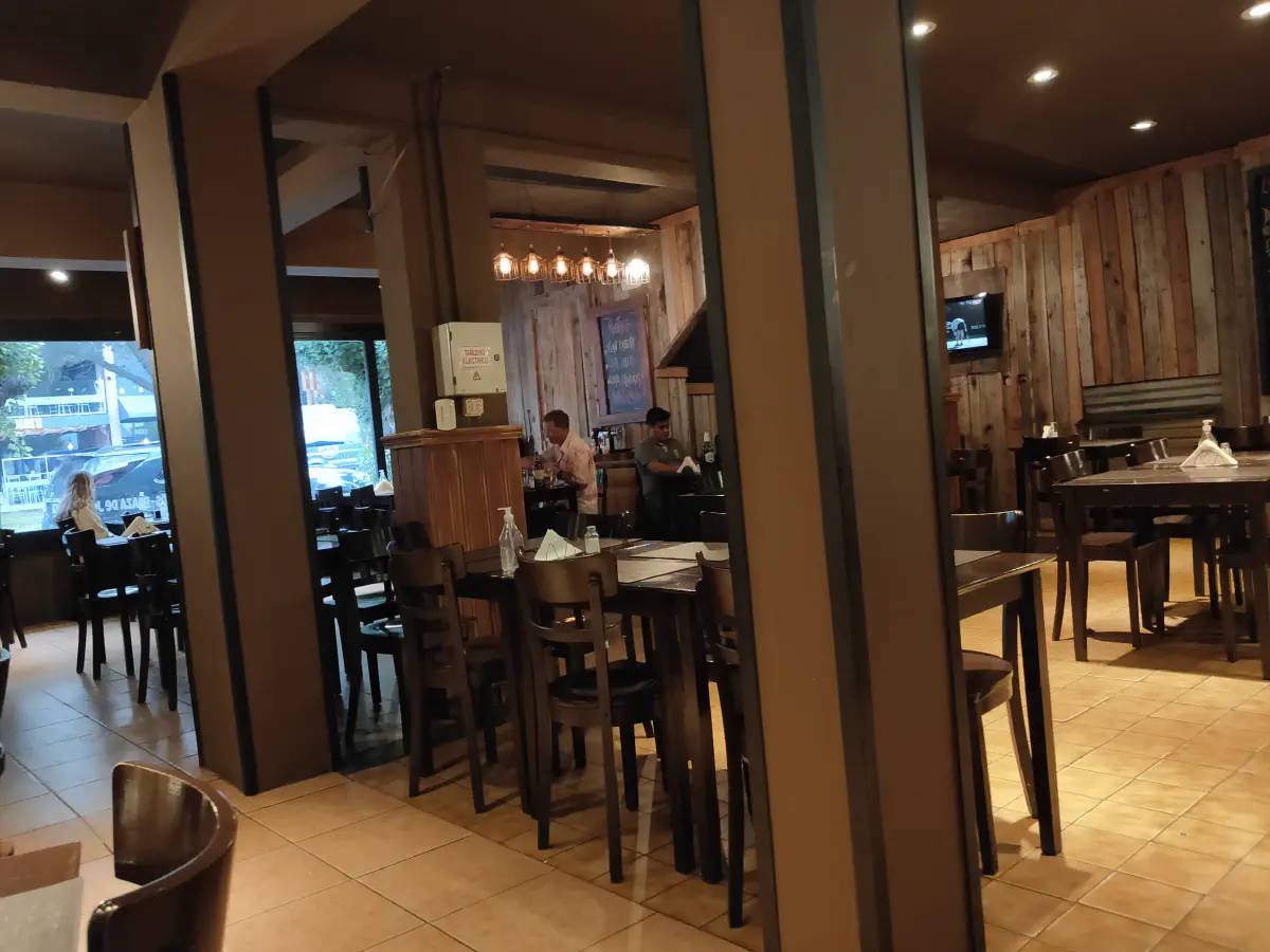 木材内装のレストラン店内。テーブルと椅子が並ぶ