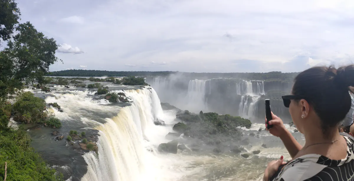ブラジル側展望台から霧に包まれたイグアスの滝を撮影する観光客