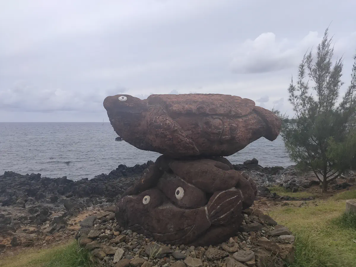 海辺の岩場に置かれた魚をかたどった石彫刻