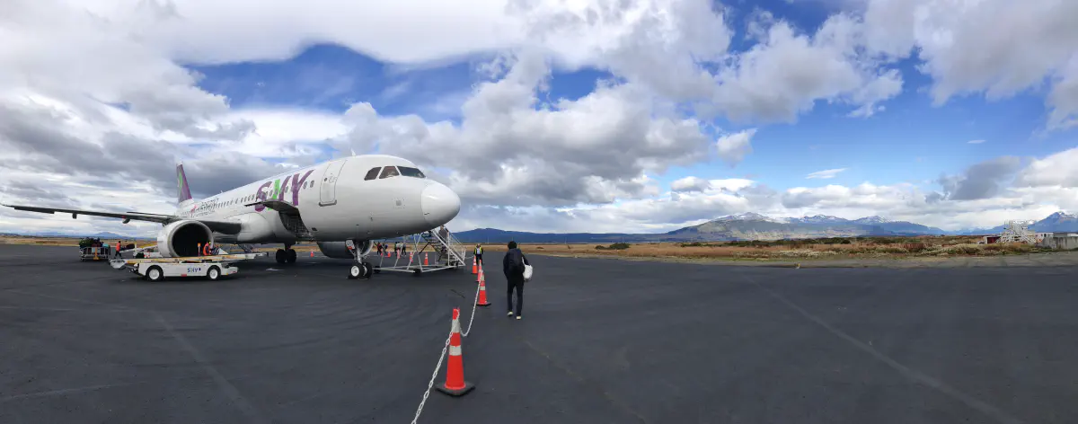 パタゴニアの広大な空港エプロンに停まるSKY Airline機体と、背後に広がる草原と山並み