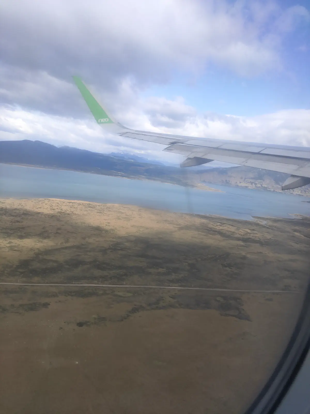 機窓から見えるパタゴニアの湖と山並みの空撮