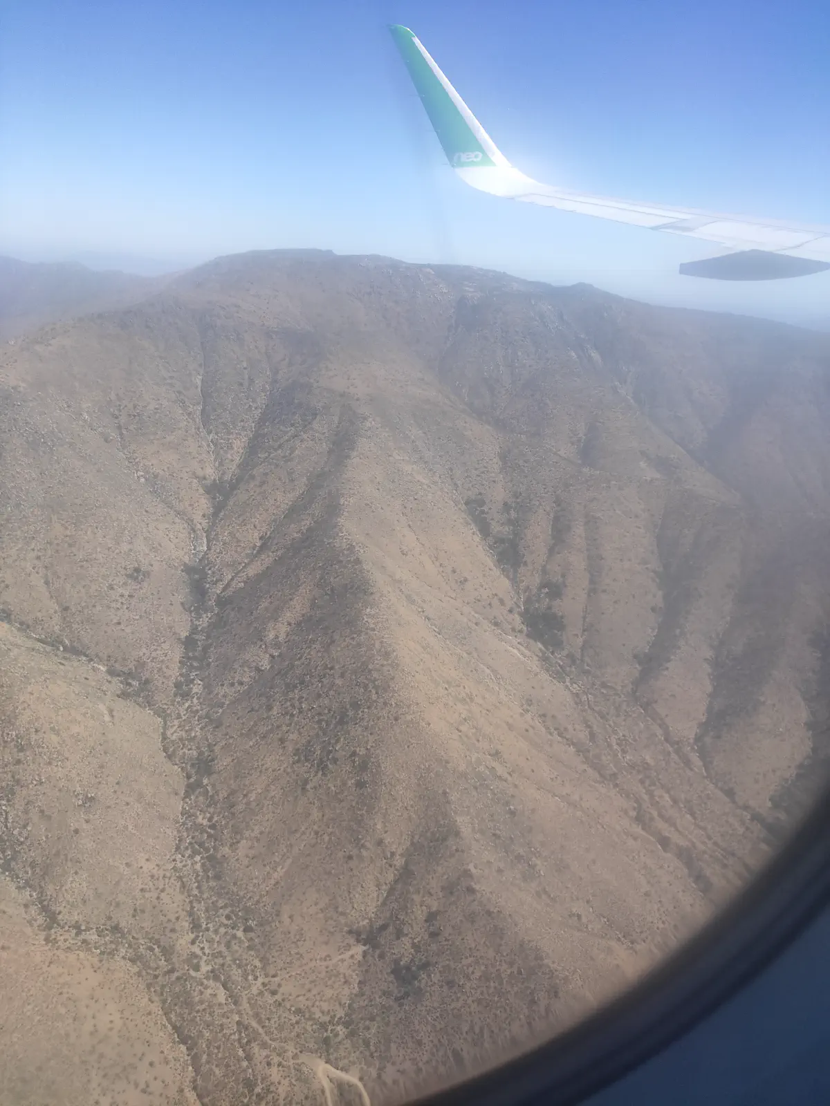 機窓から見える乾燥した丘陵地帯