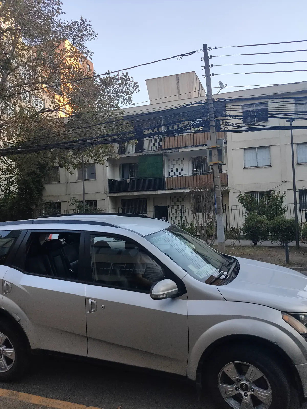 サンティアゴの街路に停まるSUVと古いアパート