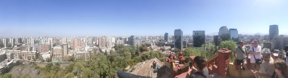 高台から見渡したサンティアゴ市街地のパノラマ。高層ビル群と緑の公園、背後に霞むアンデス山脈