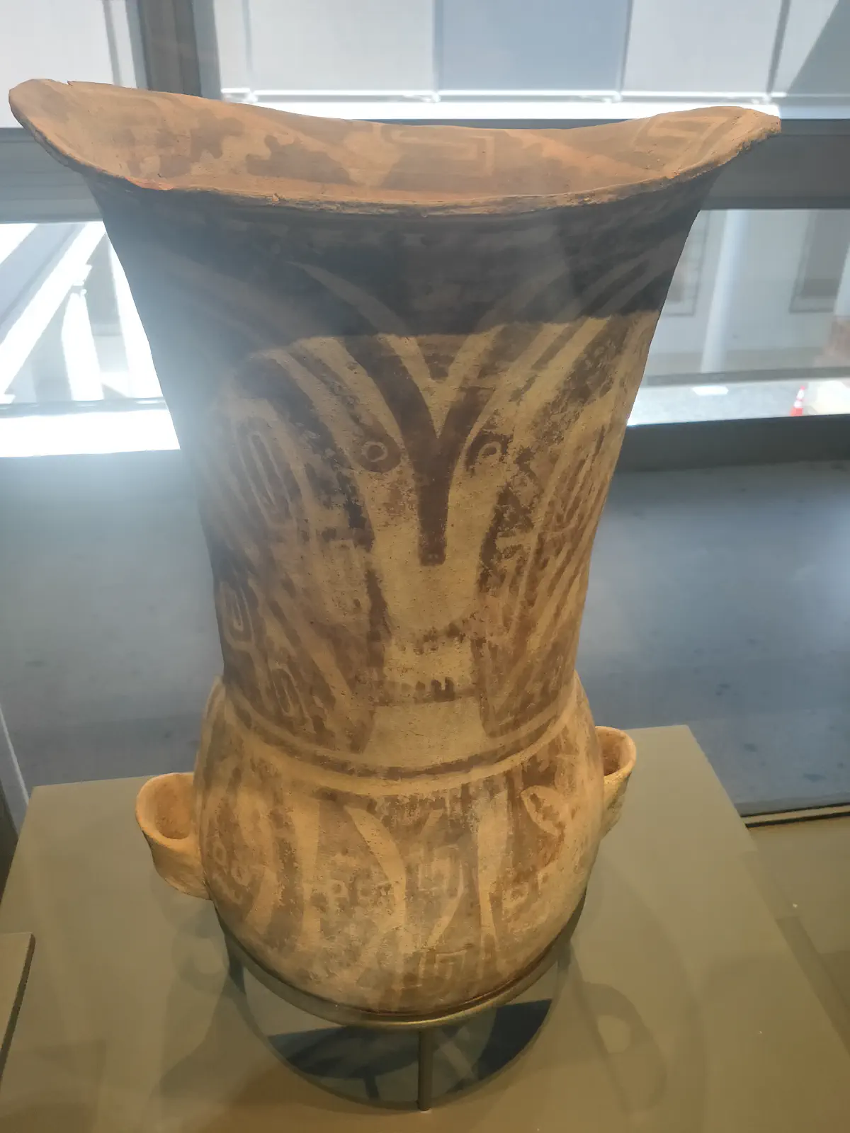 人面のような模様が描かれた先コロンブス期の大型土器。ラッパ状に広がった口を持つ